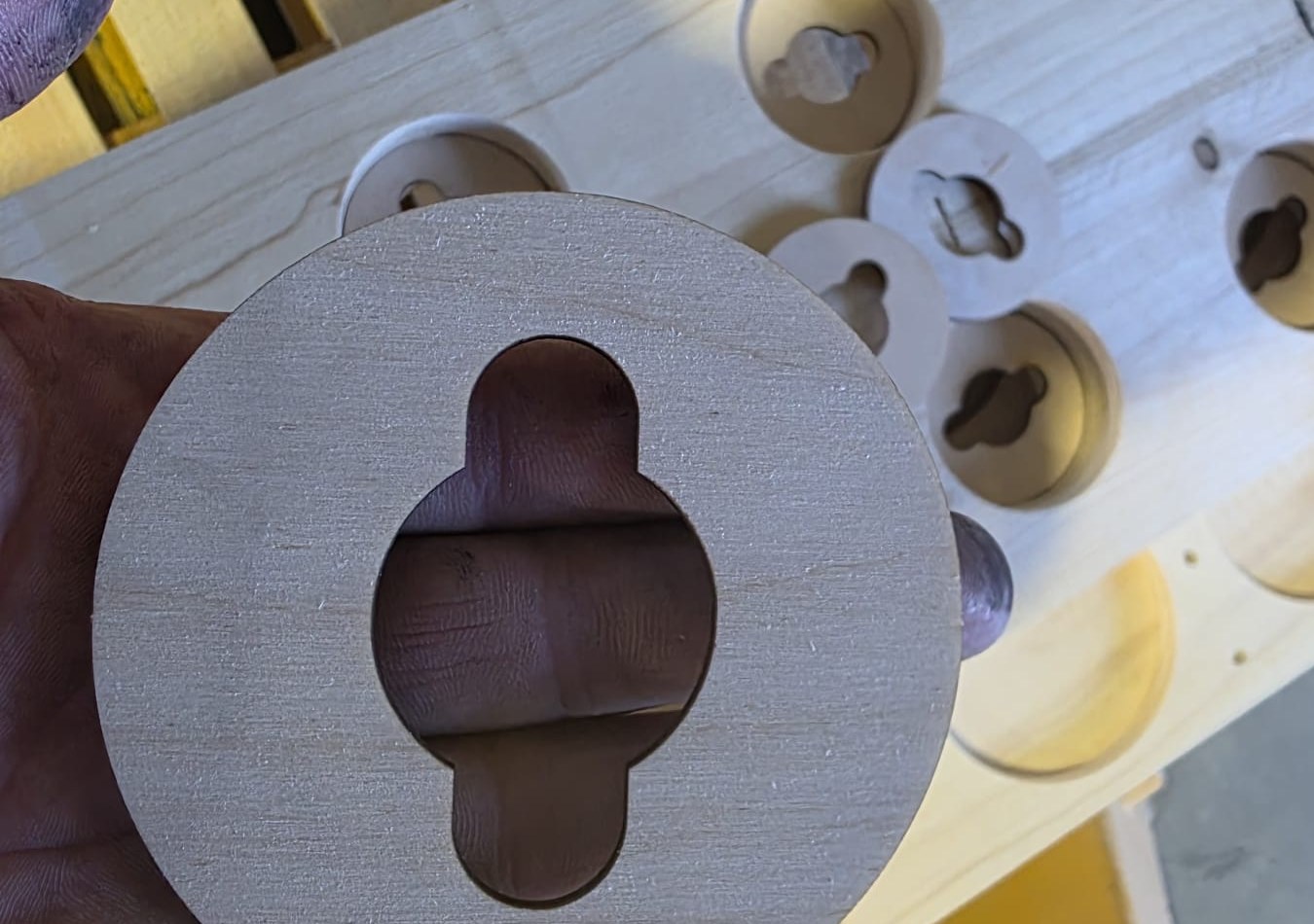 Circular machined wooden insert with a shaped opening and matching parts
